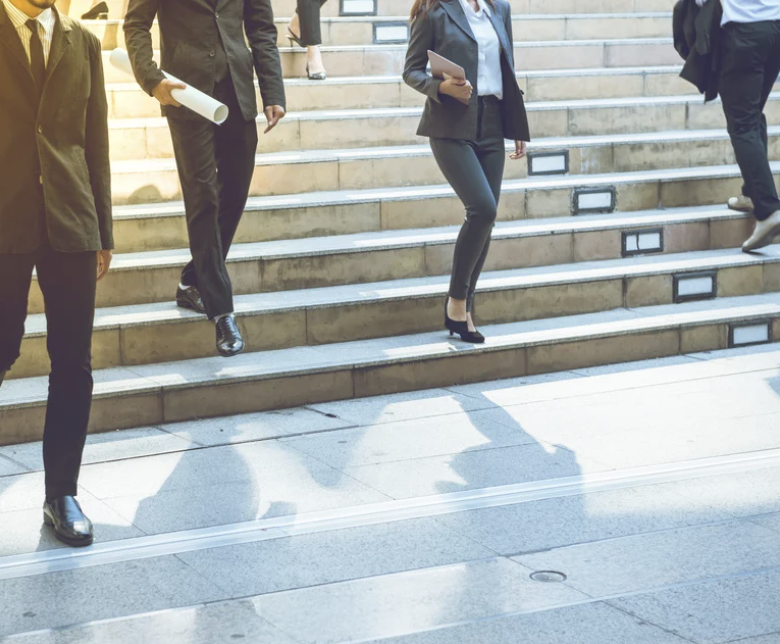 jovens advogado descendo uma escada com vestimentas da profissão (não aprecem rostos)